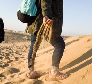 Low section of woman standing in desert