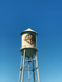 Low angle view of water tower against clear blue sky