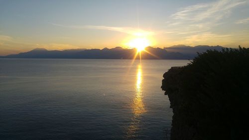 Scenic view of sea and mountains during sunset