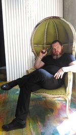 Portrait of man sitting on chair at home