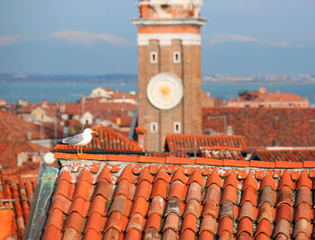 View of roof and building by sea against sky