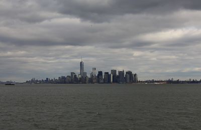 Buildings in city against cloudy sky
