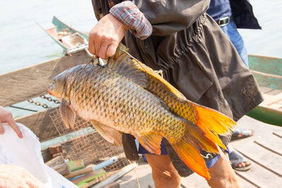 Midsection of man holding fish