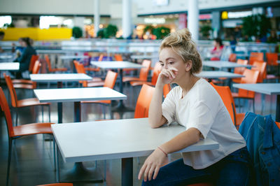 Woman sitting on chair at supermarket