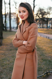 Young woman standing against trees