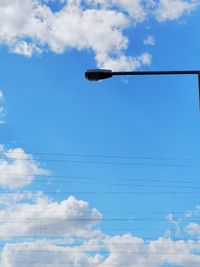 Low angle view of street light against blue sky