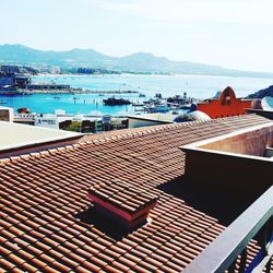 High angle view of houses by sea against sky