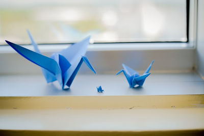 Close-up of paper crafts on window sill