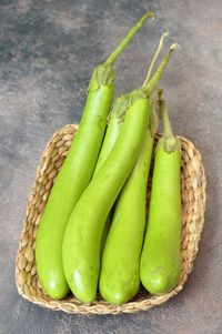 Close-up of green eggplants in basket on table