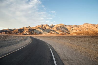 Empty road with mountains in background