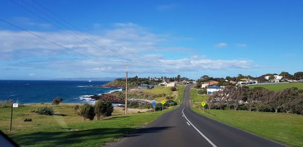 Road by sea against sky
