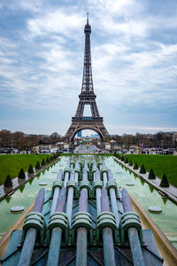 Fountain in champ de mars with eiffel tower against sky