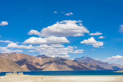 Scenic view of sea and mountains against blue sky