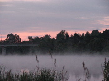 Scenic view of lake against sky at sunset