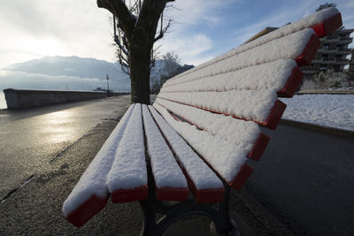 Snow covered bench on footpath