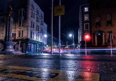 Illuminated city street during rainy season at night