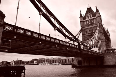 Low angle view of bridge over river against buildings
