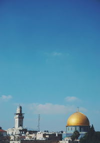 Buildings in city against blue sky