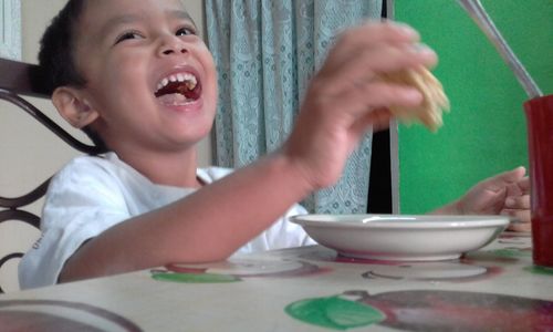 Boy eating food in kitchen