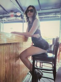 Portrait of young woman sitting in sunglasses
