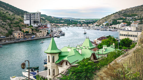 High angle view of city by river against sky