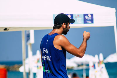 Rear view of man standing against blue wall