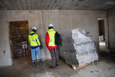 Architect of the building project and construction manager walk around the interior of new building