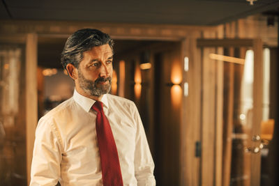 Thoughtful lawyer looking away while standing in legal office