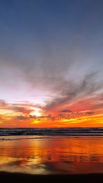 Scenic view of sea against dramatic sky during sunset