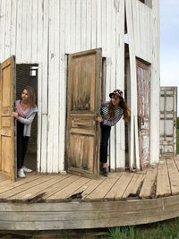 Full length of woman standing against door