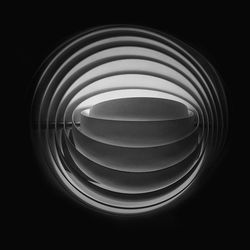 Close-up of illuminated lighting equipment against black background