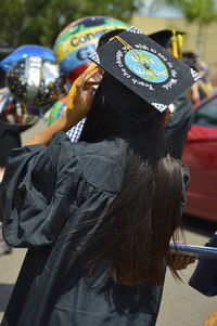 Rear view of woman wearing mortarboard on street