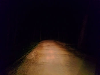 Empty road in illuminated dark room