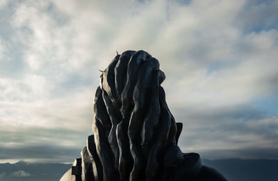 Low angle view of statue against cloudy sky