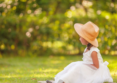 Rear view of woman sitting in garden