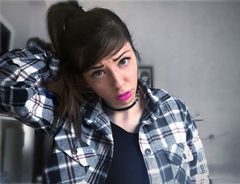 Portrait of young woman against wall