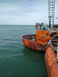 Boat moored on sea against sky