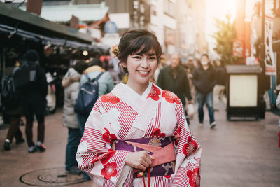 Portrait of smiling young woman standing outdoors