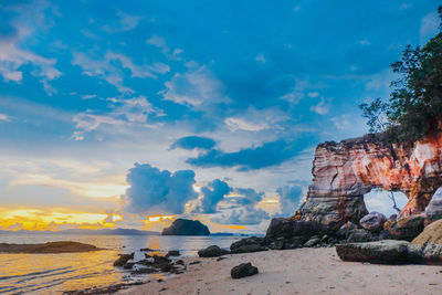 Rock formations on beach against sky