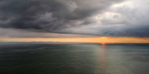 Scenic view of sea against storm clouds