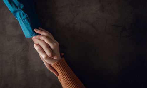 Close-up of holding hands on table