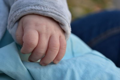 Close-up of baby hand on mother lap