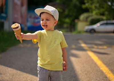 Portrait of cute boy standing on road