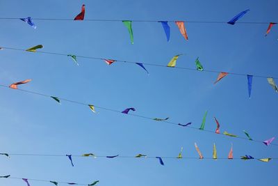 Low angle view of flags hanging against sky