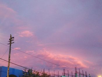 Low angle view of silhouette electricity pylon against sky