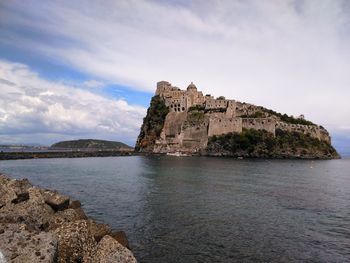 Historic building by sea against sky