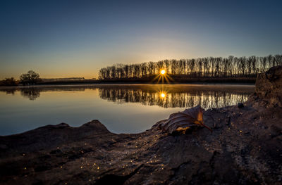 Scenic view of lake against sky at sunset