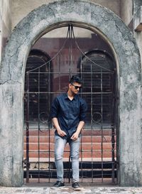 Portrait of man standing against brick wall