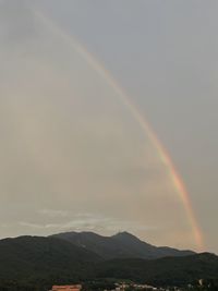Scenic view of rainbow over mountains against sky