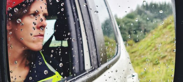 Portrait of woman seen through wet window in rainy season